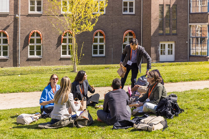 a group of relaxed people on meadow having a picknick